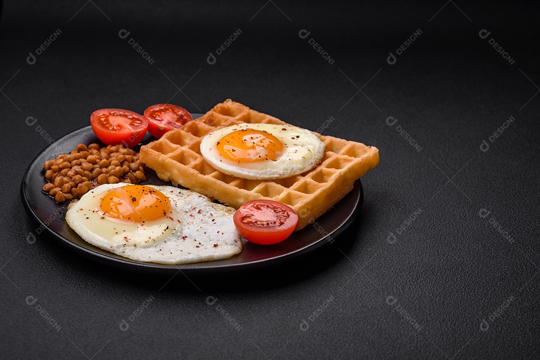 Delicioso café da manhã composto por ovo frito, waffle belga, lentilhas, microgreens com especiarias e ervas em um fundo escuro de concreto