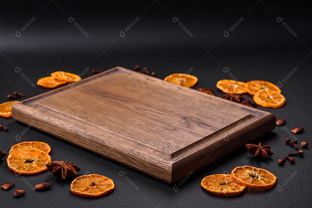 Deliciosos muffins de chocolate e fatias redondas secas de tangerina de cor laranja brilhante sobre um fundo textural escuro