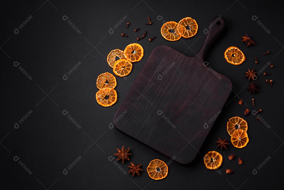 Fatias secas de forma redonda de tangerina de cor laranja brilhante sobre um fundo textural escuro