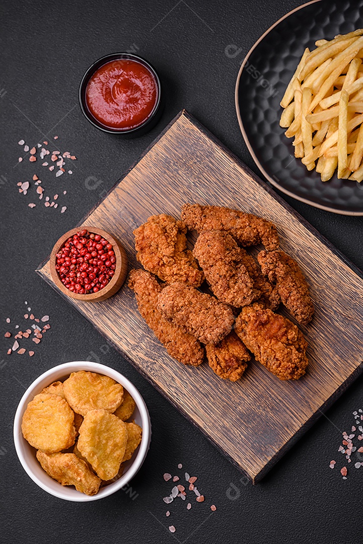 Deliciosas asas de frango empanadas crocantes grelhadas com especiarias e ervas em um fundo escuro de concreto