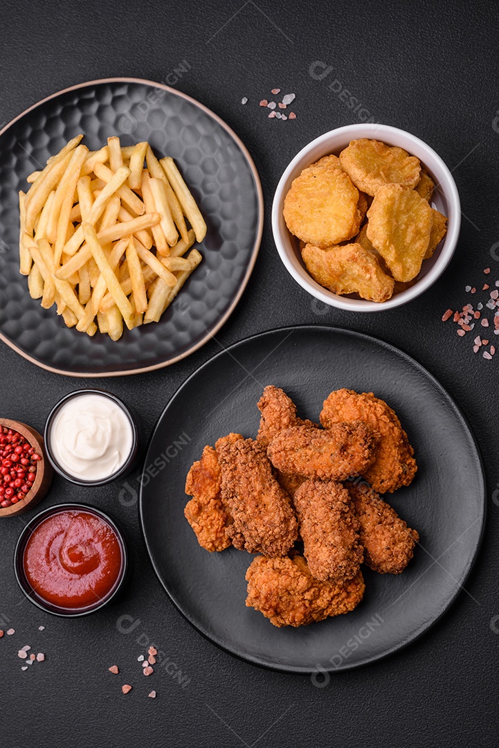 Deliciosas asas de frango empanadas crocantes grelhadas com especiarias e ervas em um fundo escuro de concreto