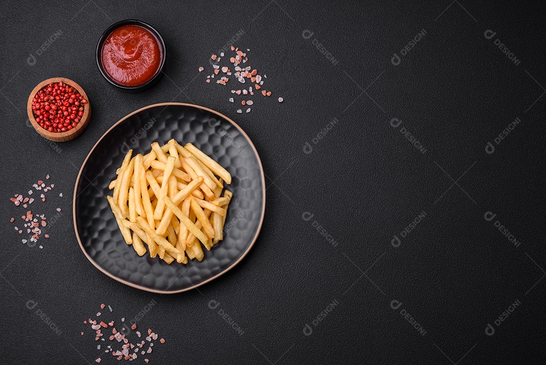 Deliciosas batatas fritas crocantes com sal e especiarias em um fundo escuro de concreto. Alimentos não saudáveis, fast food