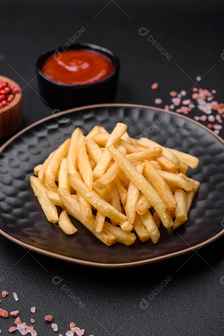 Deliciosas batatas fritas crocantes com sal e especiarias em um fundo escuro de concreto. Alimentos não saudáveis, fast food