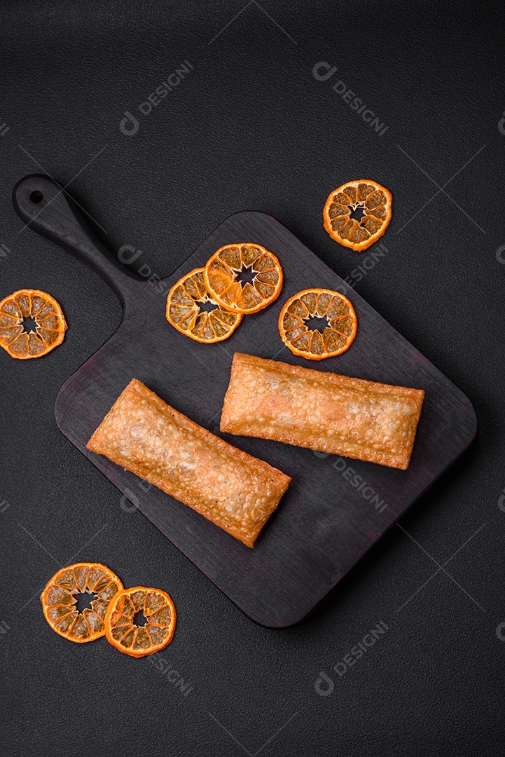 Deliciosa torta crocante fresca com geléia de cereja em uma tábua de madeira sobre um fundo escuro de concreto