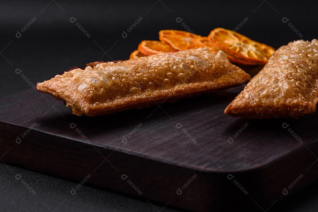 Deliciosa torta crocante fresca com geléia de cereja em uma tábua de madeira sobre um fundo escuro de concreto