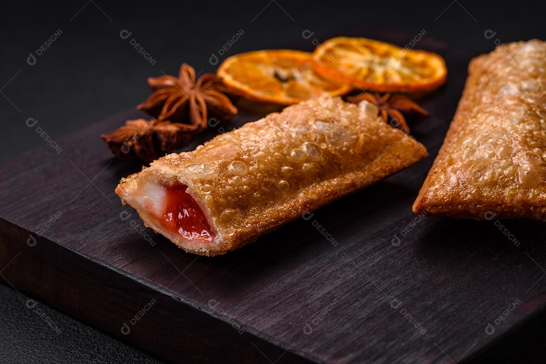 Deliciosa torta crocante fresca com geléia de cereja em uma tábua de madeira sobre um fundo escuro de concreto