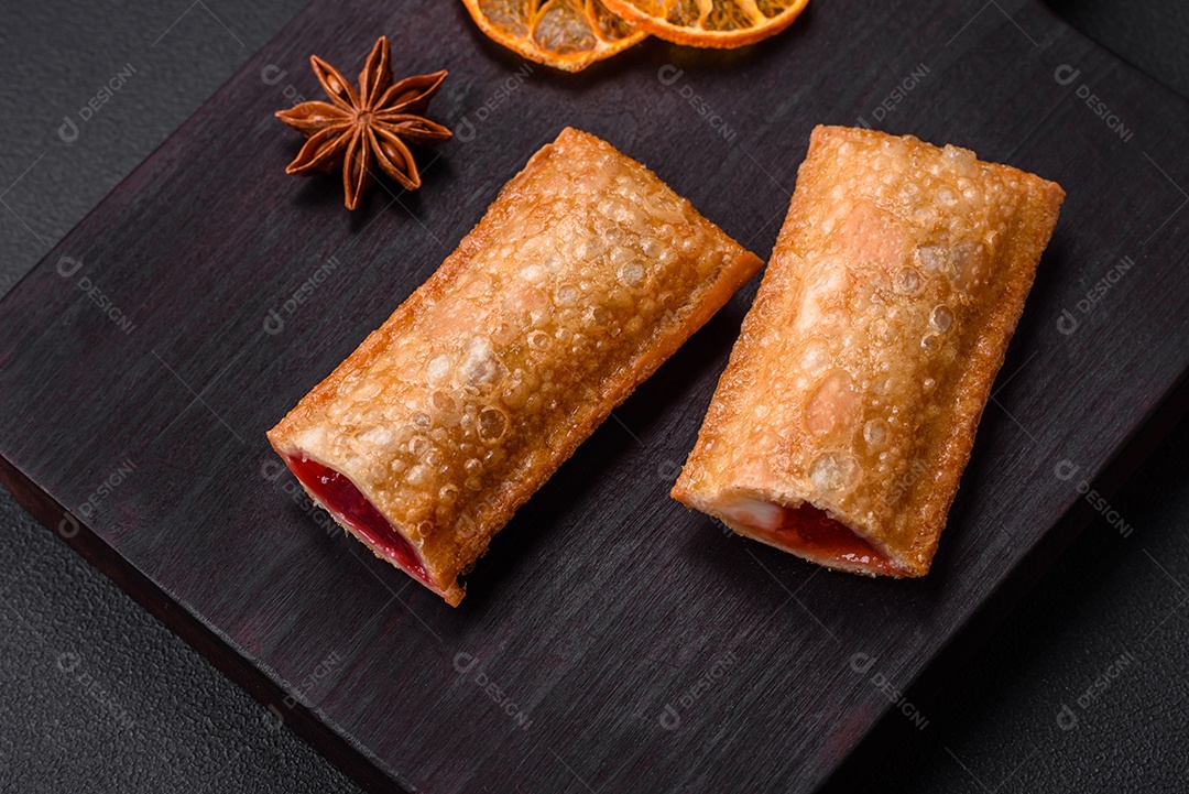 Deliciosa torta crocante fresca com geléia de cereja em uma tábua de madeira sobre um fundo escuro de concreto