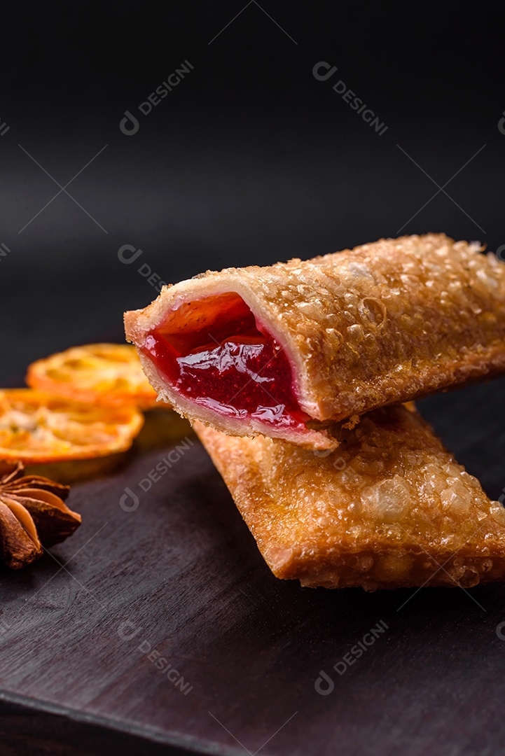 Deliciosa torta crocante fresca com geléia de cereja em uma tábua de madeira sobre um fundo escuro de concreto