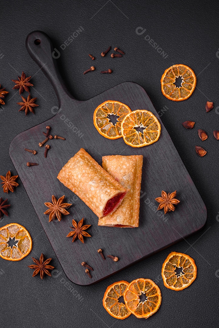 Deliciosa torta crocante fresca com geléia de cereja em uma tábua de madeira sobre um fundo escuro de concreto