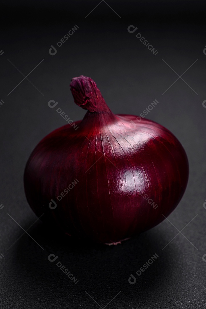 Cebola vermelha crua fresca em fundo de concreto texturizado escuro. Cozinhando em casa