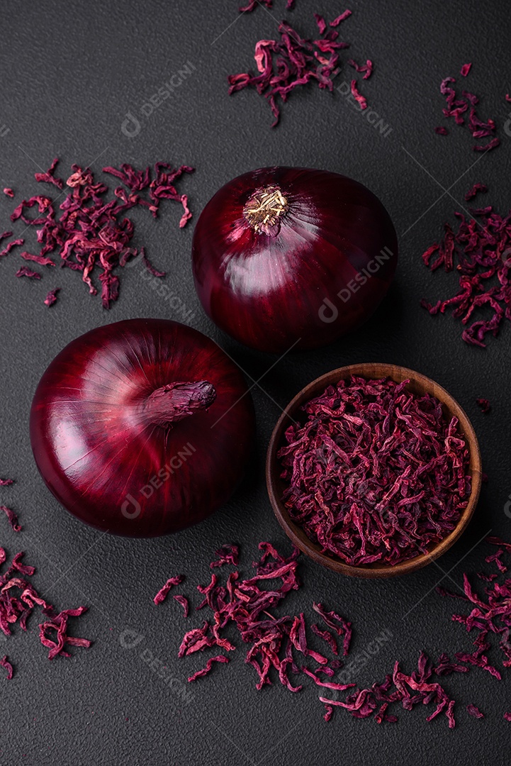 Cebola vermelha crua fresca em fundo de concreto texturizado escuro. Cozinhando em casa