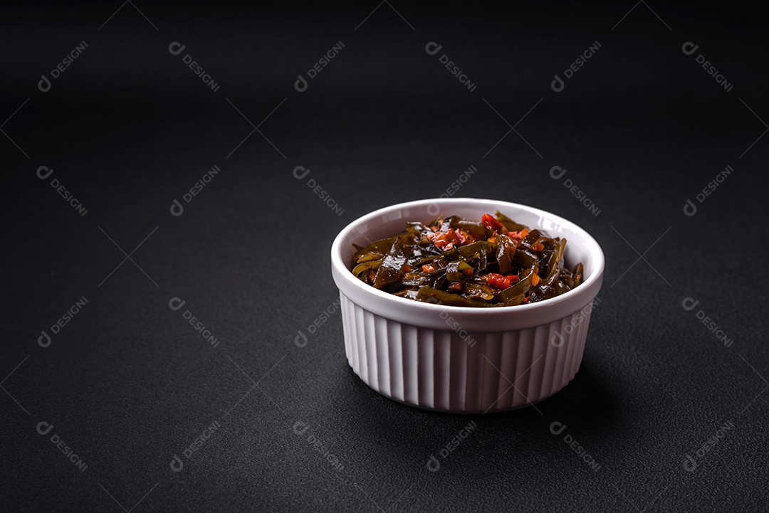 Deliciosas algas marinadas com páprica, especiarias e sal sobre um fundo escuro de concreto. Deliciosa salada vegetariana