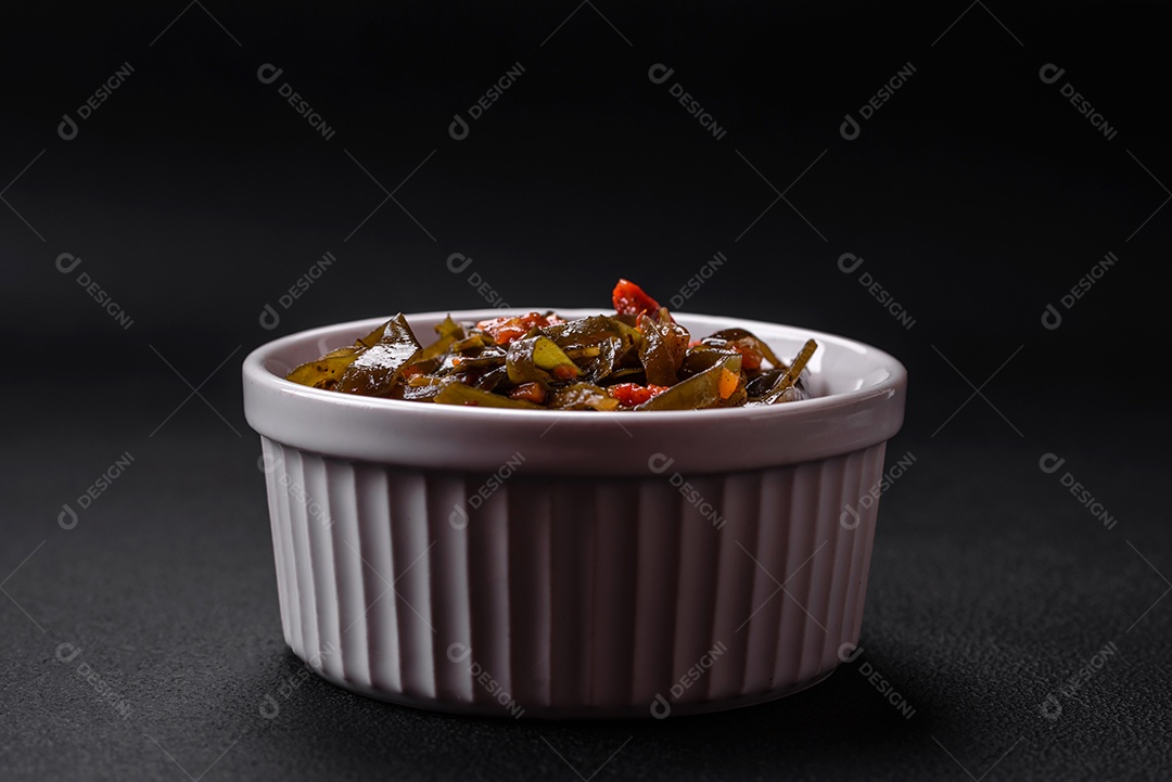 Deliciosas algas marinadas com páprica, especiarias e sal sobre um fundo escuro de concreto. Deliciosa salada vegetariana
