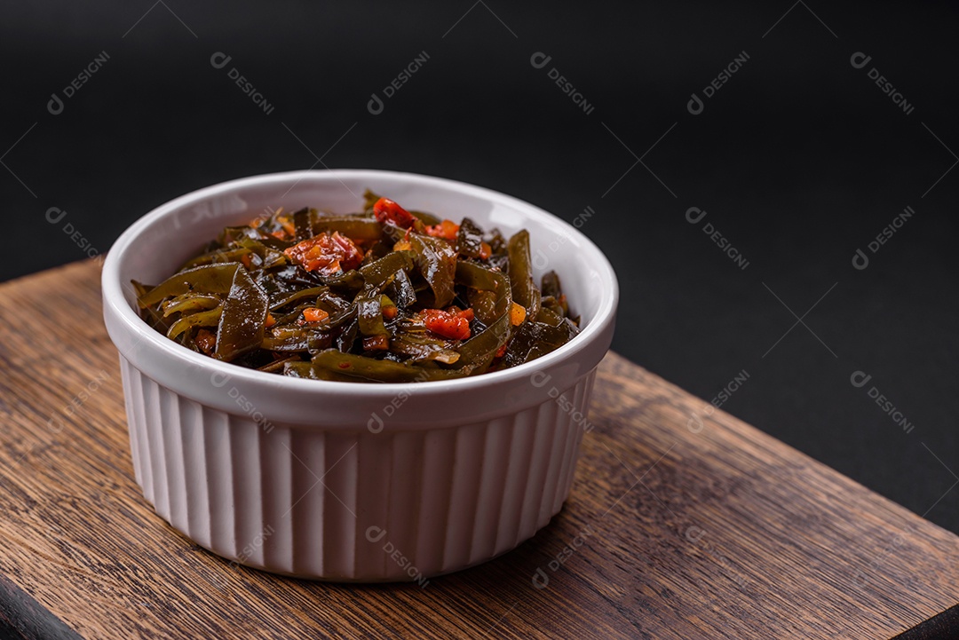 Deliciosas algas marinadas com páprica, especiarias e sal sobre um fundo escuro de concreto. Deliciosa salada vegetariana