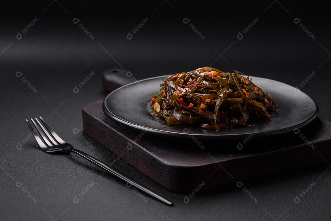 Deliciosas algas marinadas com páprica, especiarias e sal sobre um fundo escuro de concreto. Deliciosa salada vegetariana