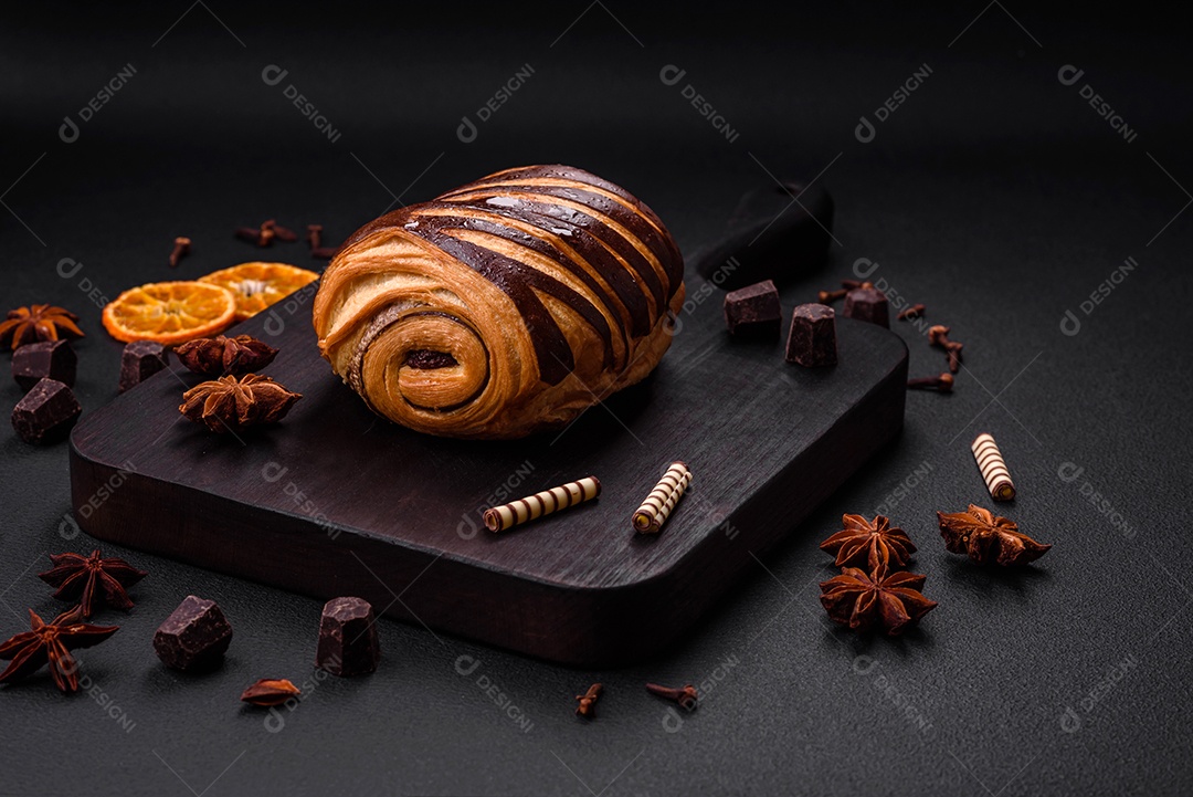 Delicioso pão de canela assado fresco e crocante em fundo escuro de concreto