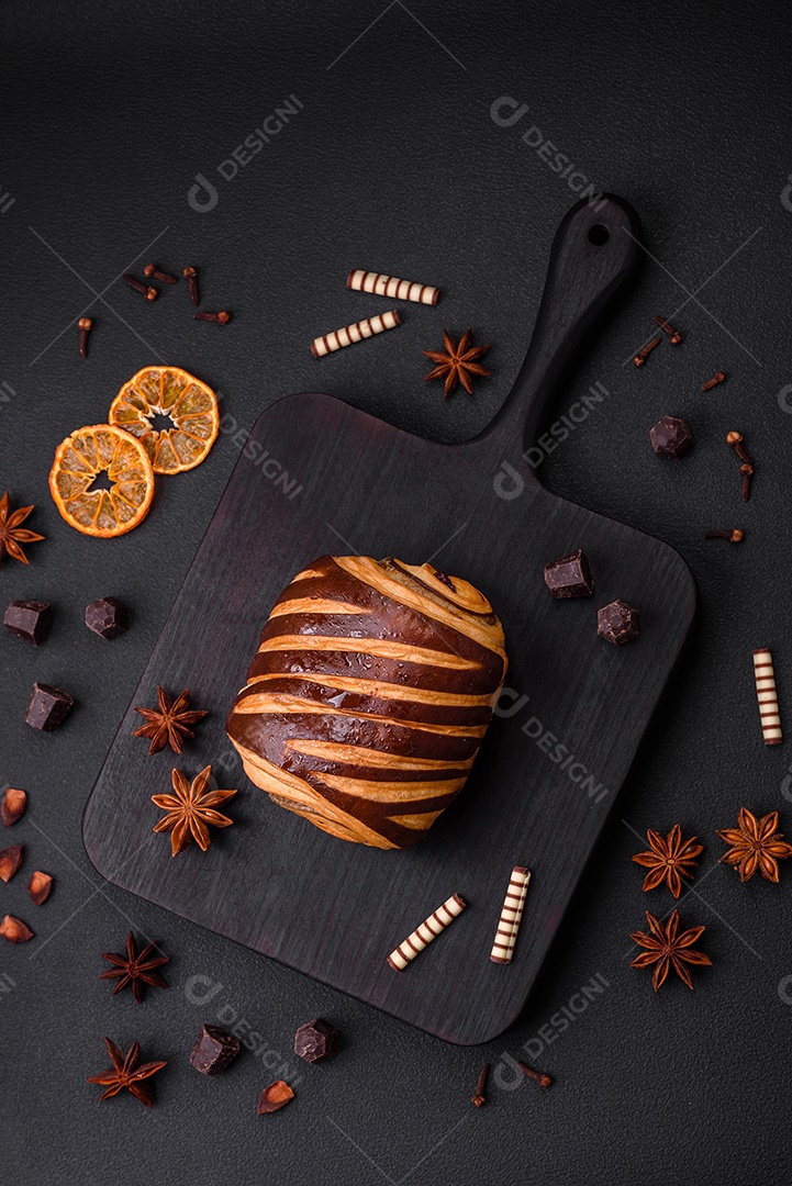 Delicioso pão de canela assado fresco e crocante em fundo escuro de concreto