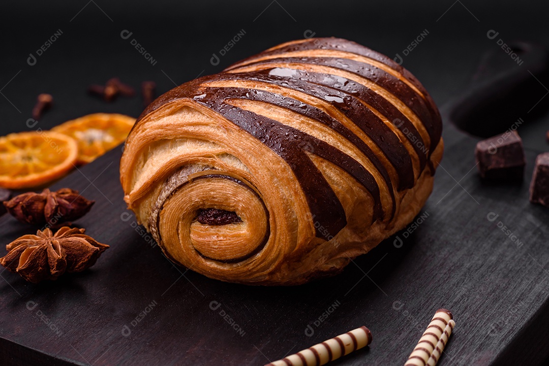 Delicioso pão de canela assado fresco e crocante em fundo escuro de concreto