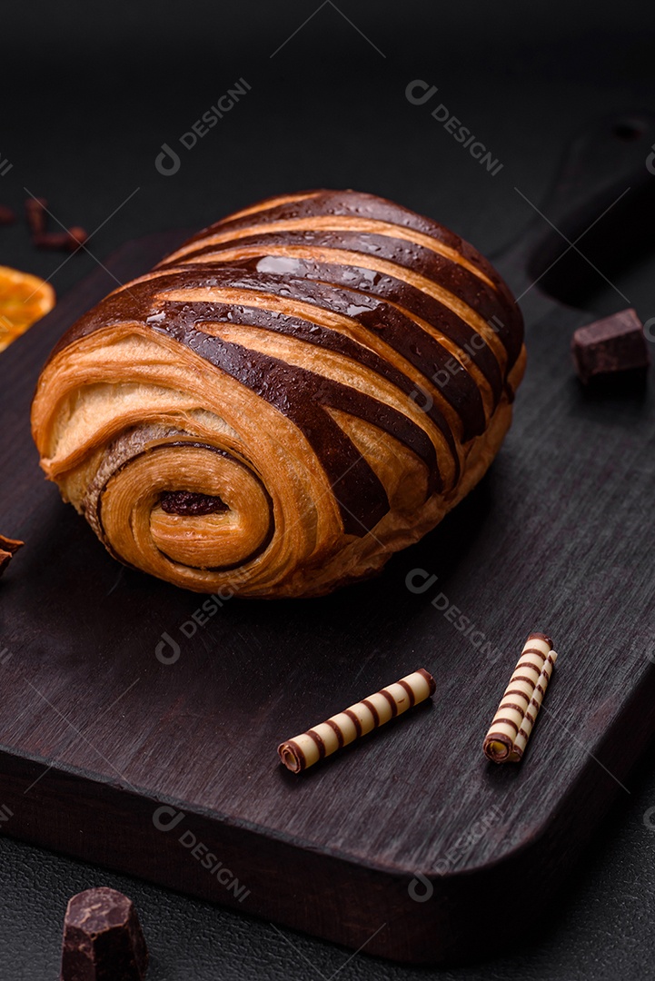 Delicioso pão de canela assado fresco e crocante em fundo escuro de concreto