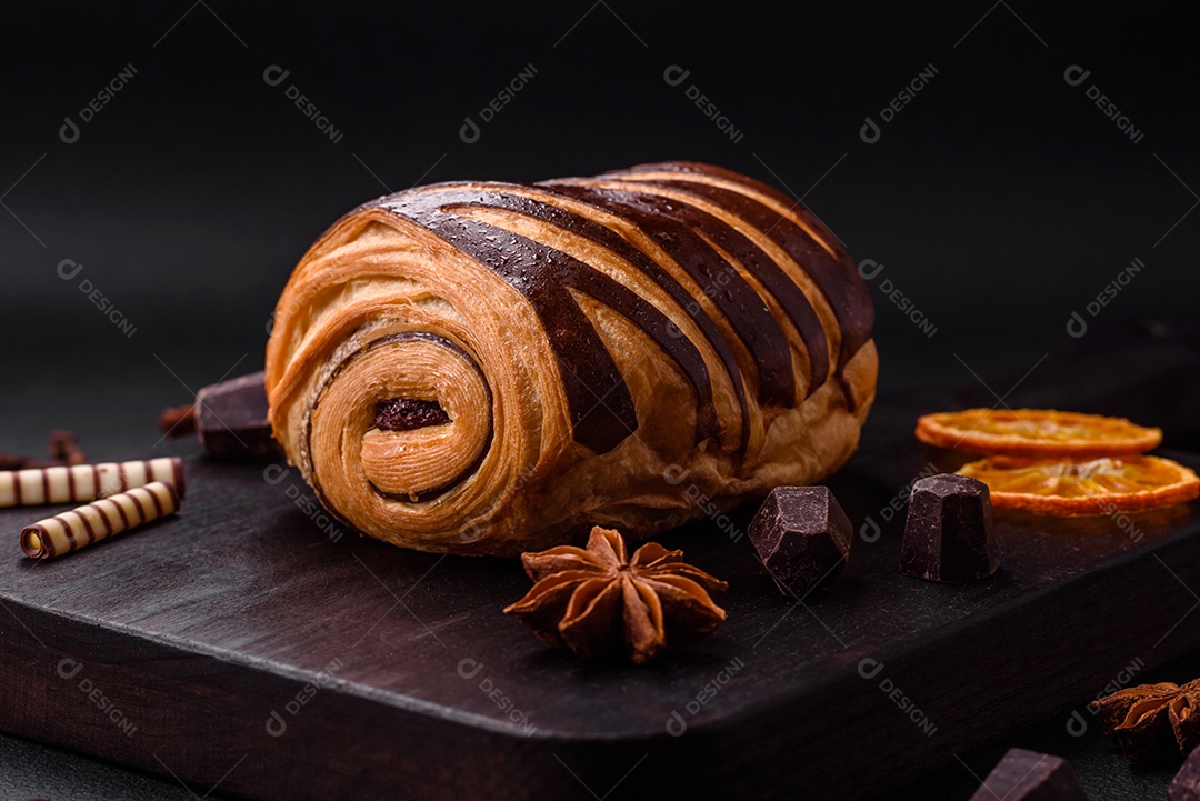 Delicioso pão de canela assado fresco e crocante em fundo escuro de concreto