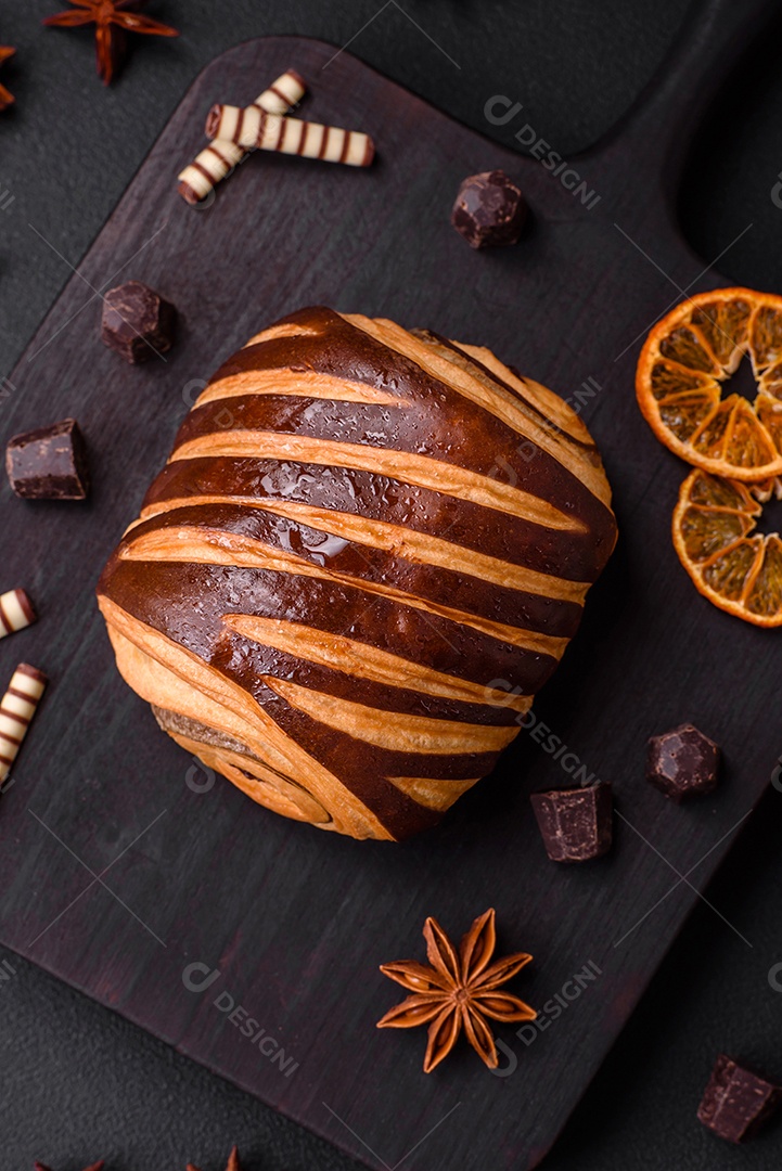 Delicioso pão de canela assado fresco e crocante em fundo escuro de concreto