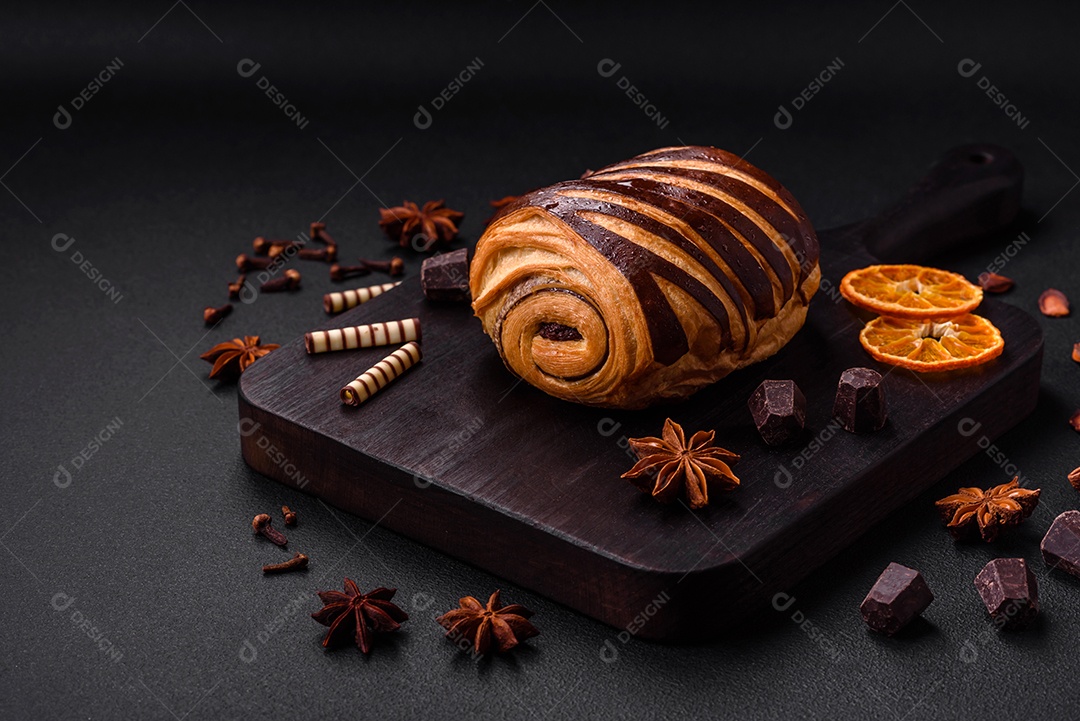 Delicioso pão de canela assado fresco e crocante em fundo escuro de concreto