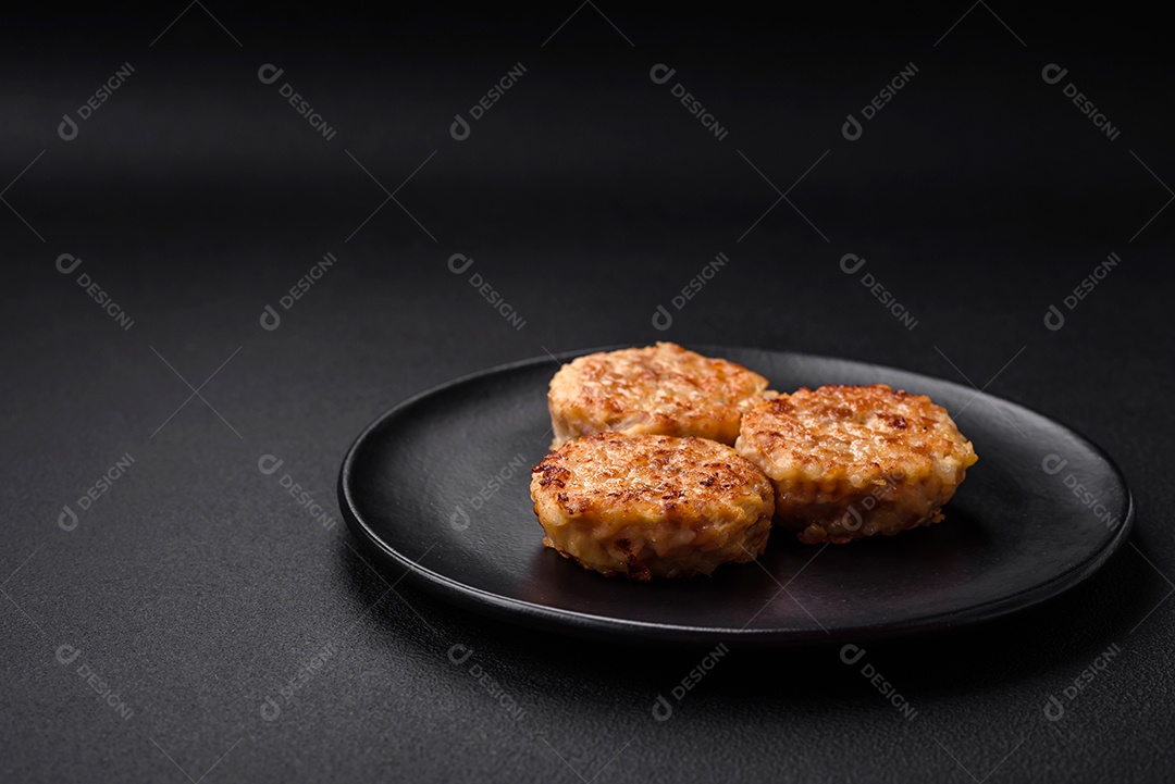 Deliciosas costeletas ou almôndegas frescas com especiarias e ervas sobre um fundo escuro de concreto