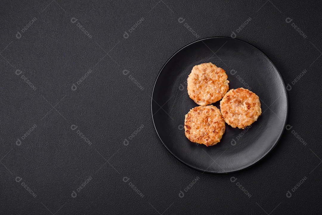 Deliciosas costeletas ou almôndegas frescas com especiarias e ervas sobre um fundo escuro de concreto