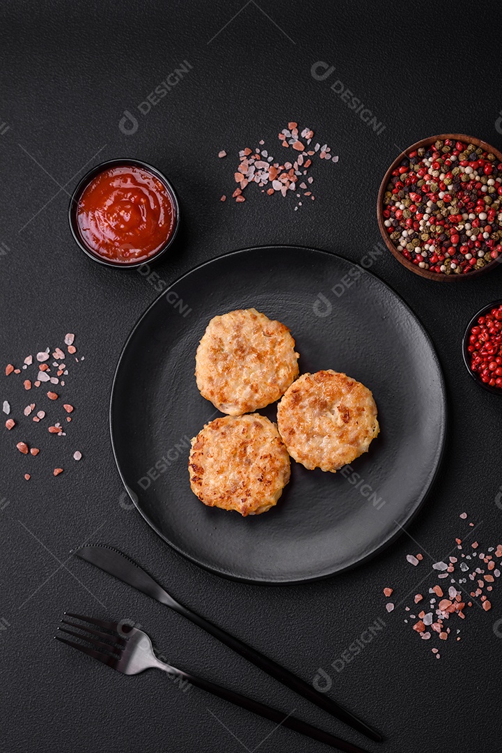 Deliciosas costeletas ou almôndegas frescas com especiarias e ervas sobre um fundo escuro de concreto