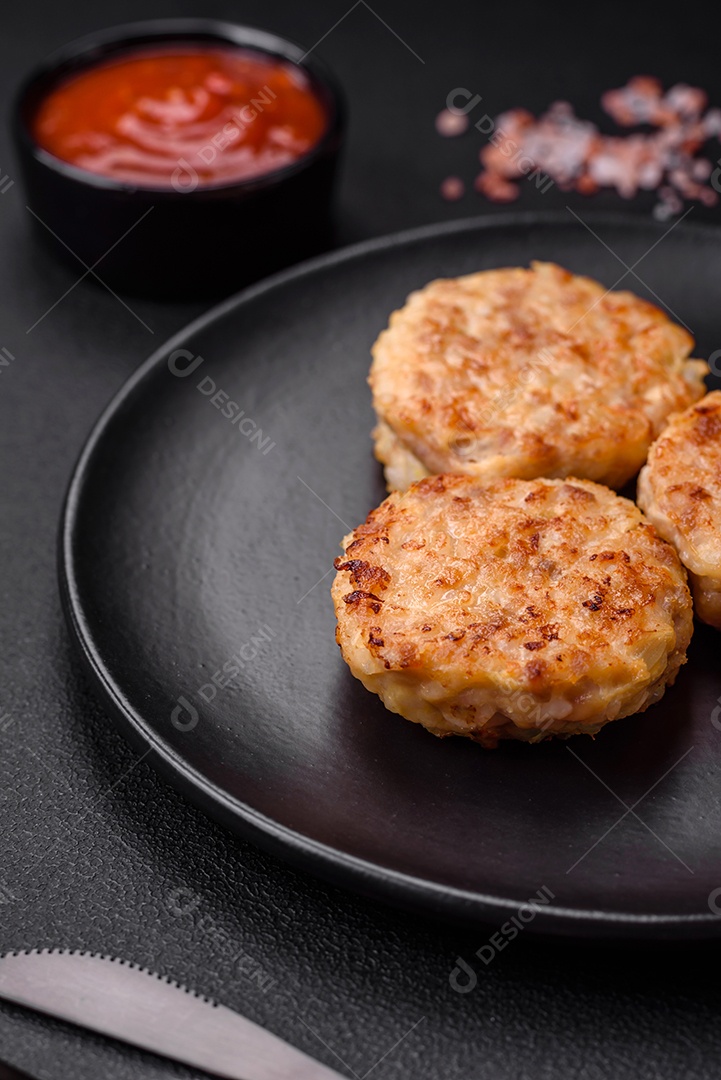 Deliciosas costeletas ou almôndegas frescas com especiarias e ervas sobre um fundo escuro de concreto