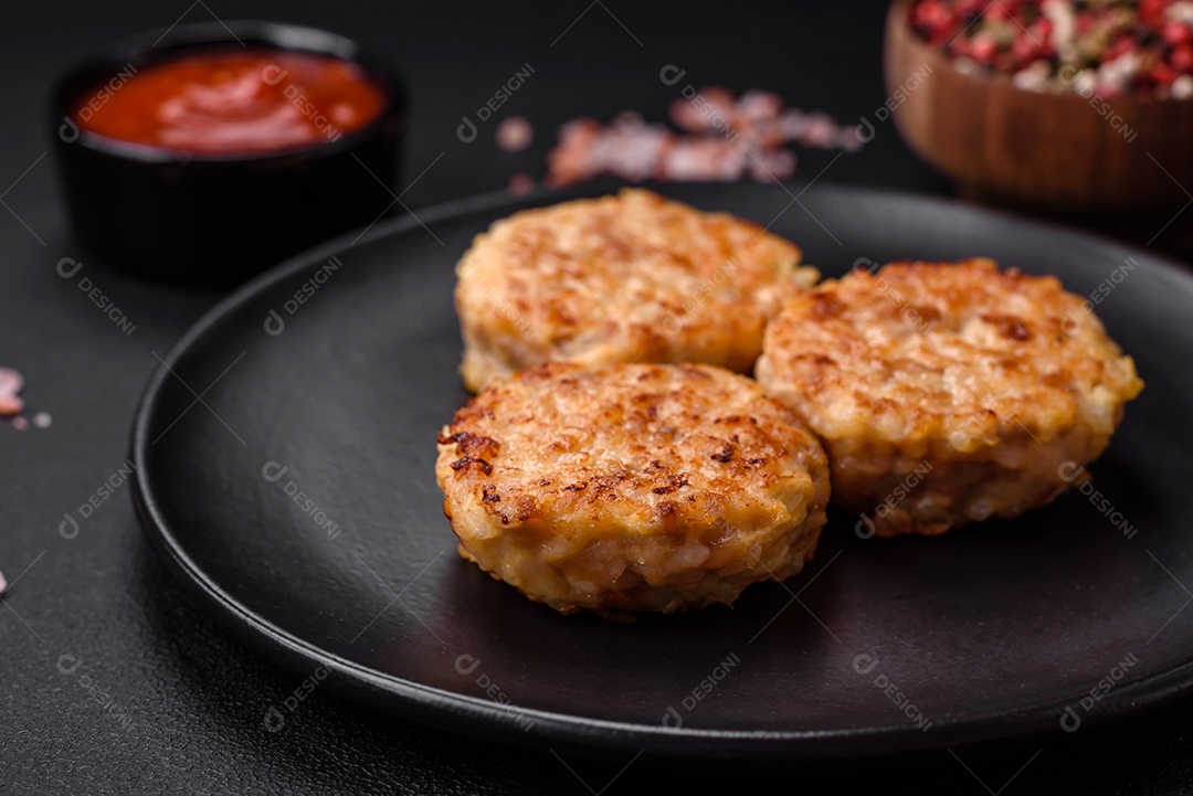 Deliciosas costeletas ou almôndegas frescas com especiarias e ervas sobre um fundo escuro de concreto