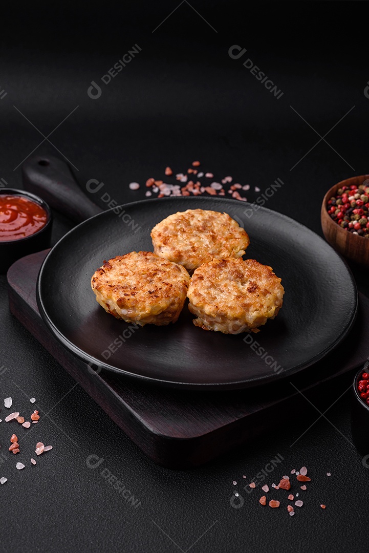 Deliciosas costeletas ou almôndegas frescas com especiarias e ervas sobre um fundo escuro de concreto