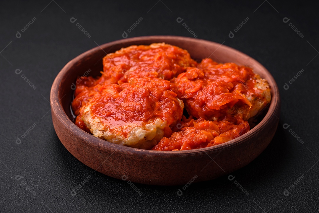Deliciosas costeletas ou almôndegas frescas com especiarias, ervas e molho de tomate sobre um fundo escuro de concreto