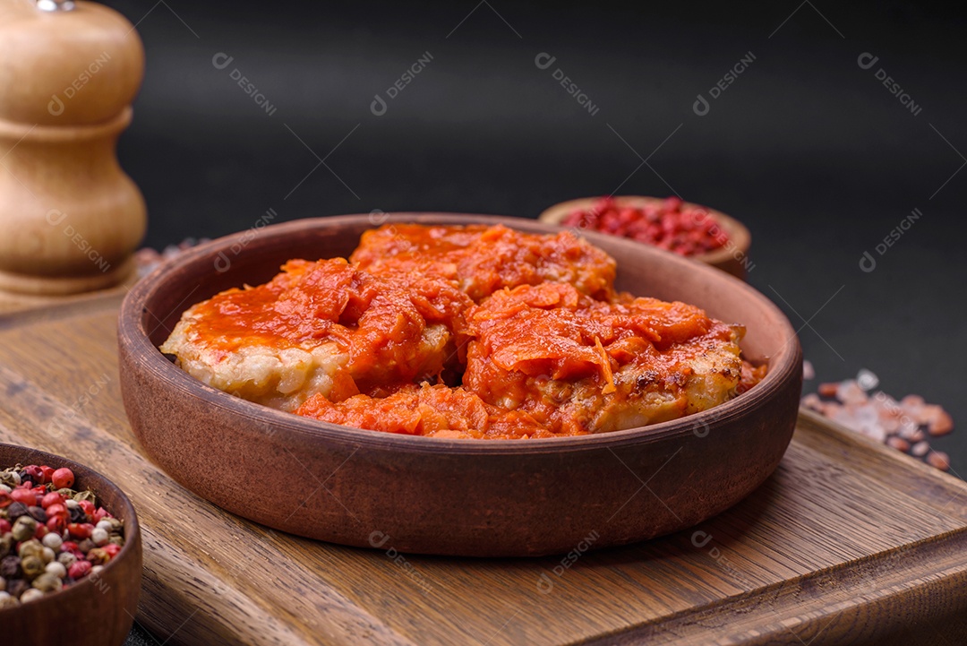 Deliciosas costeletas ou almôndegas frescas com especiarias, ervas e molho de tomate sobre um fundo escuro de concreto