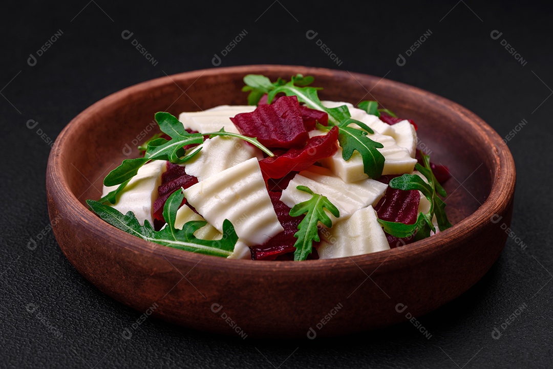 Deliciosa mussarela fresca e beterraba cozida cortada em fatias em uma placa cerâmica redonda sobre um fundo escuro de concreto