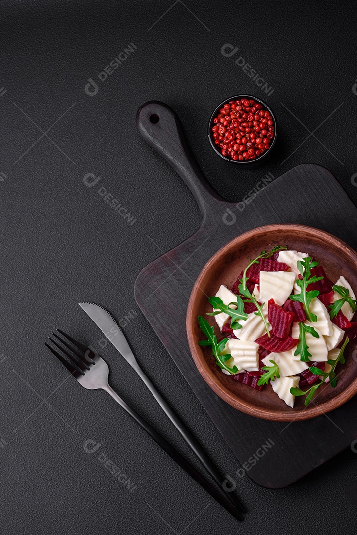 Deliciosa mussarela fresca e beterraba cozida cortada em fatias em uma placa cerâmica redonda sobre um fundo escuro de concreto