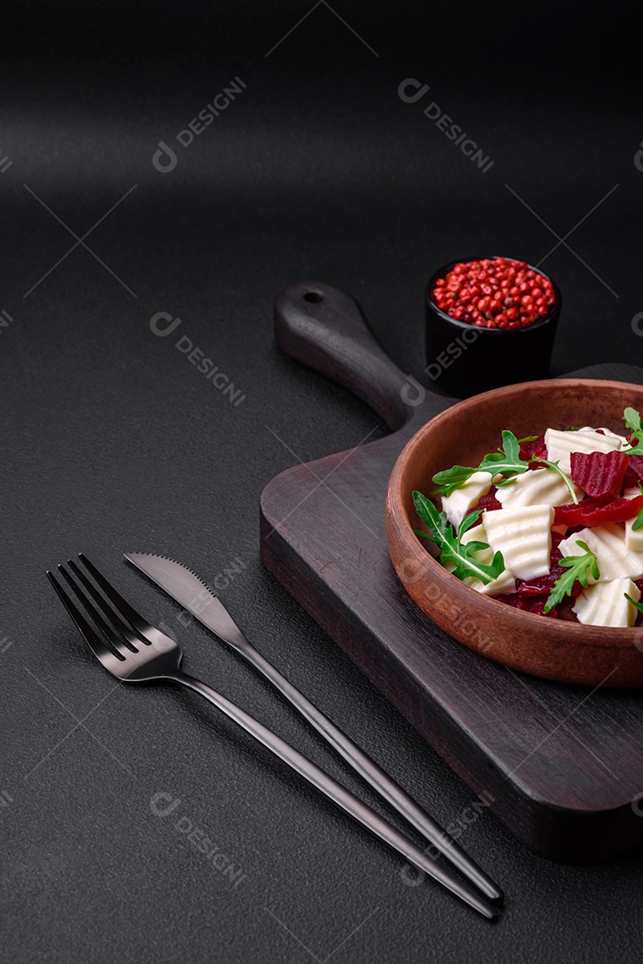 Deliciosa mussarela fresca e beterraba cozida cortada em fatias em uma placa cerâmica redonda sobre um fundo escuro de concreto