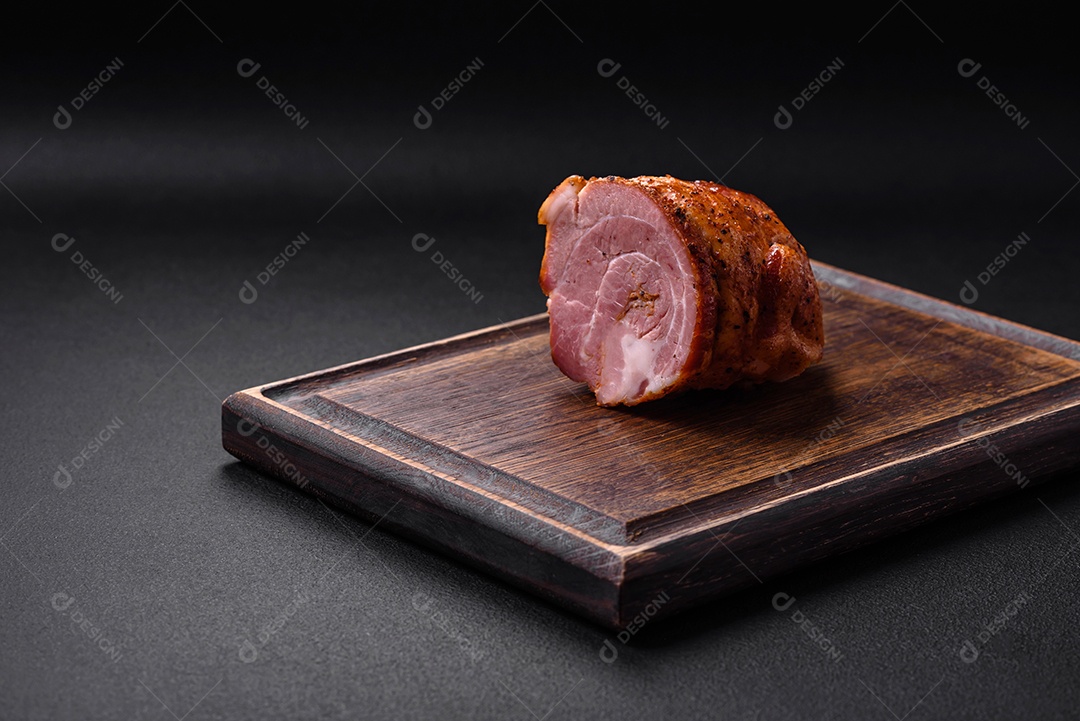 Delicioso rolo de carne fresca assada com especiarias e ervas em um fundo escuro de concreto