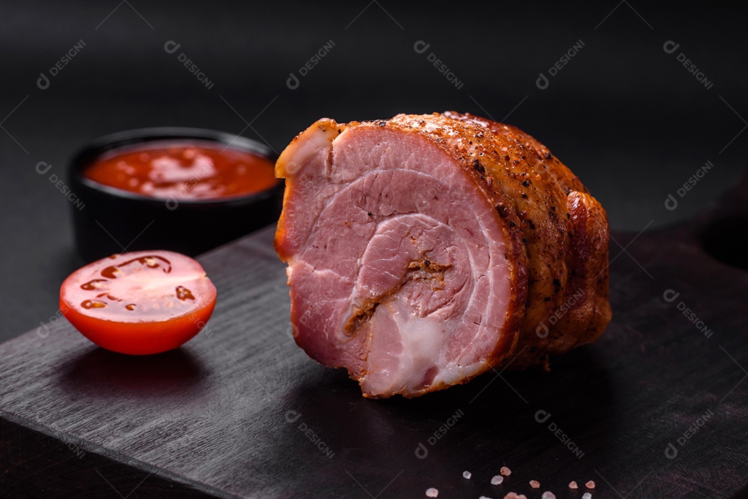 Delicioso rolo de carne fresca assada com especiarias e ervas em um fundo escuro de concreto