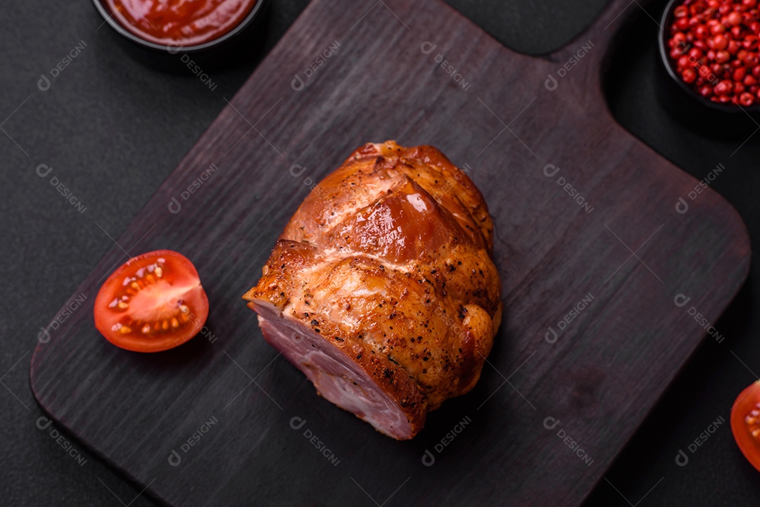 Delicioso rolo de carne fresca assada com especiarias e ervas em um fundo escuro de concreto