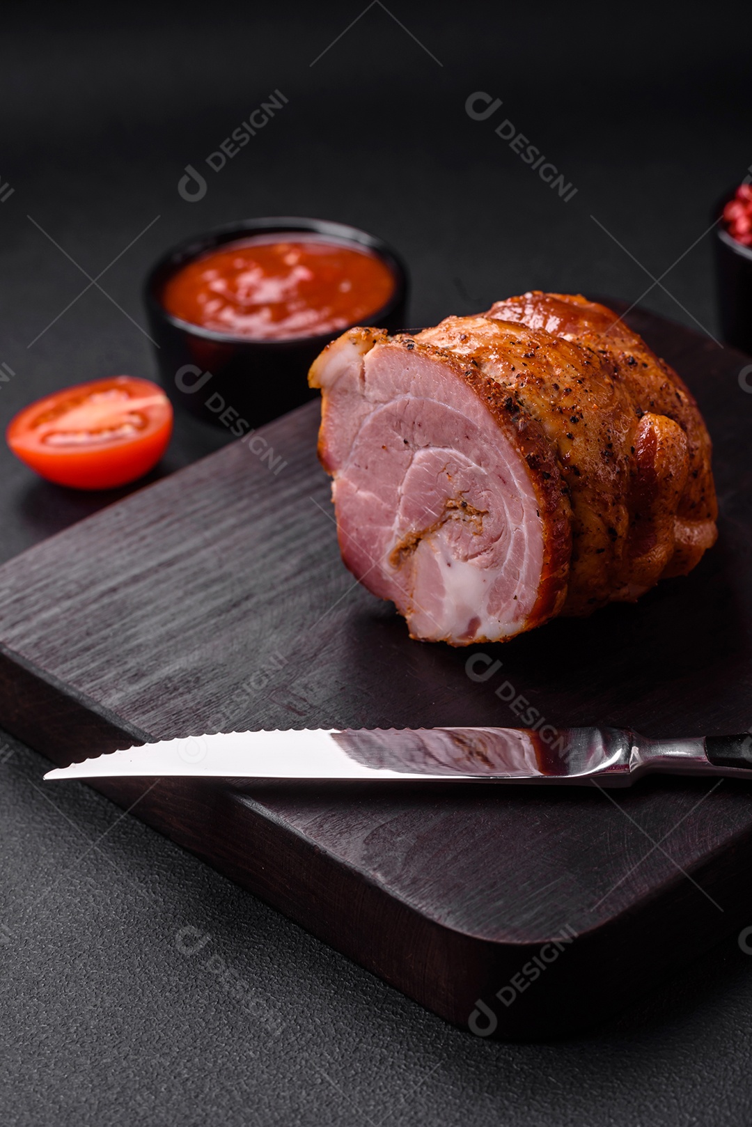 Delicioso rolo de carne fresca assada com especiarias e ervas em um fundo escuro de concreto