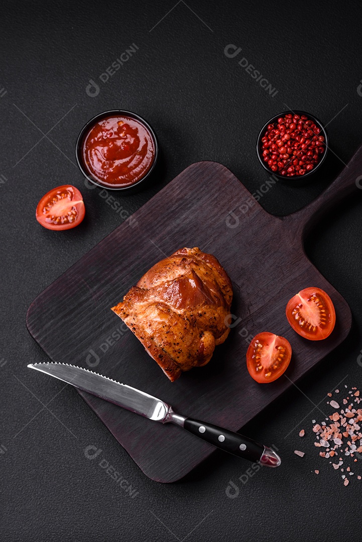 Delicioso rolo de carne fresca assada com especiarias e ervas em um fundo escuro de concreto