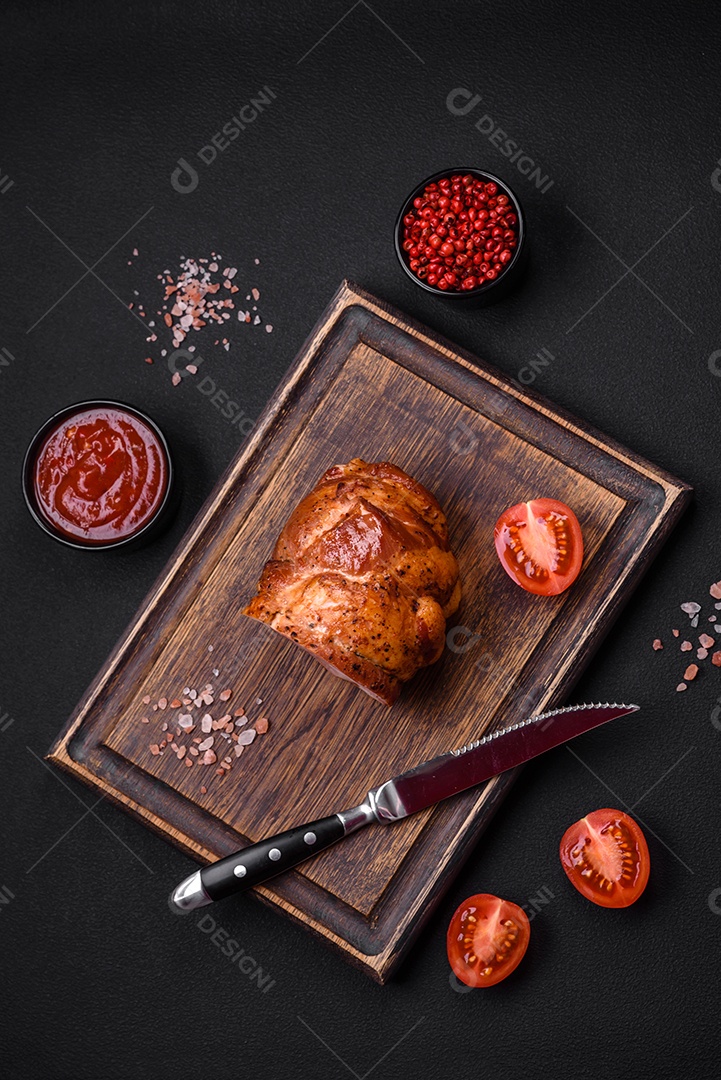 Delicioso rolo de carne fresca assada com especiarias e ervas em um fundo escuro de concreto