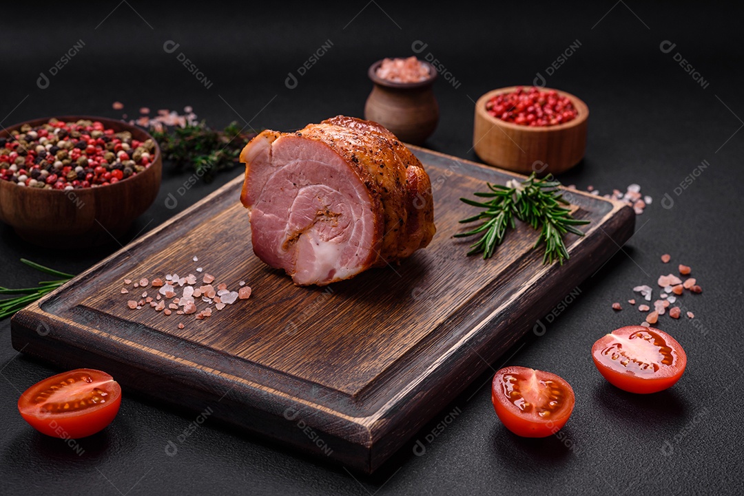 Delicioso rolo de carne fresca assada com especiarias e ervas em um fundo escuro de concreto