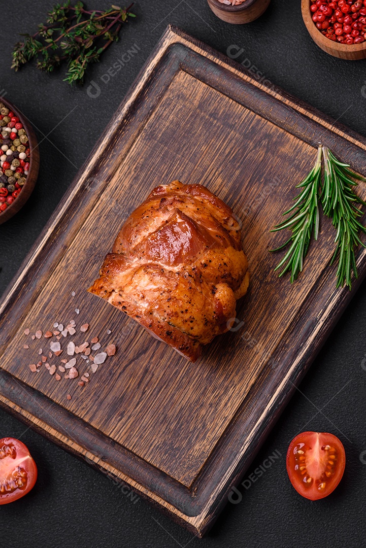 Delicioso rolo de carne fresca assada com especiarias e ervas em um fundo escuro de concreto