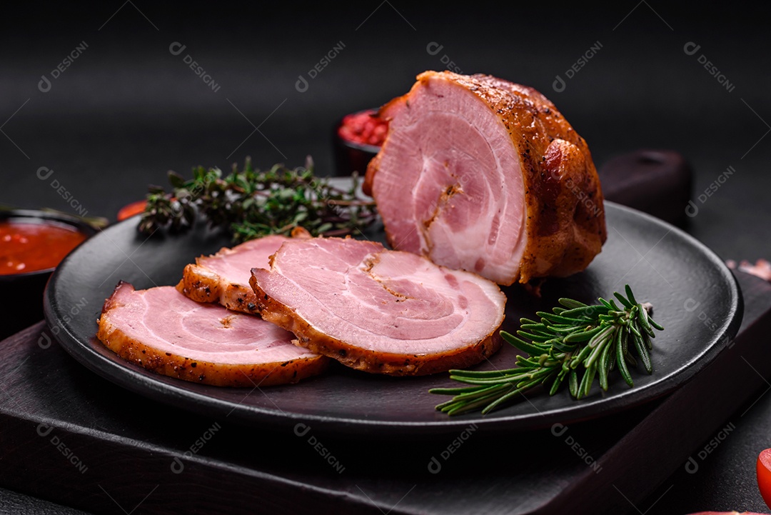 Delicioso rolo de carne fresca assada com especiarias e ervas em um fundo escuro de concreto