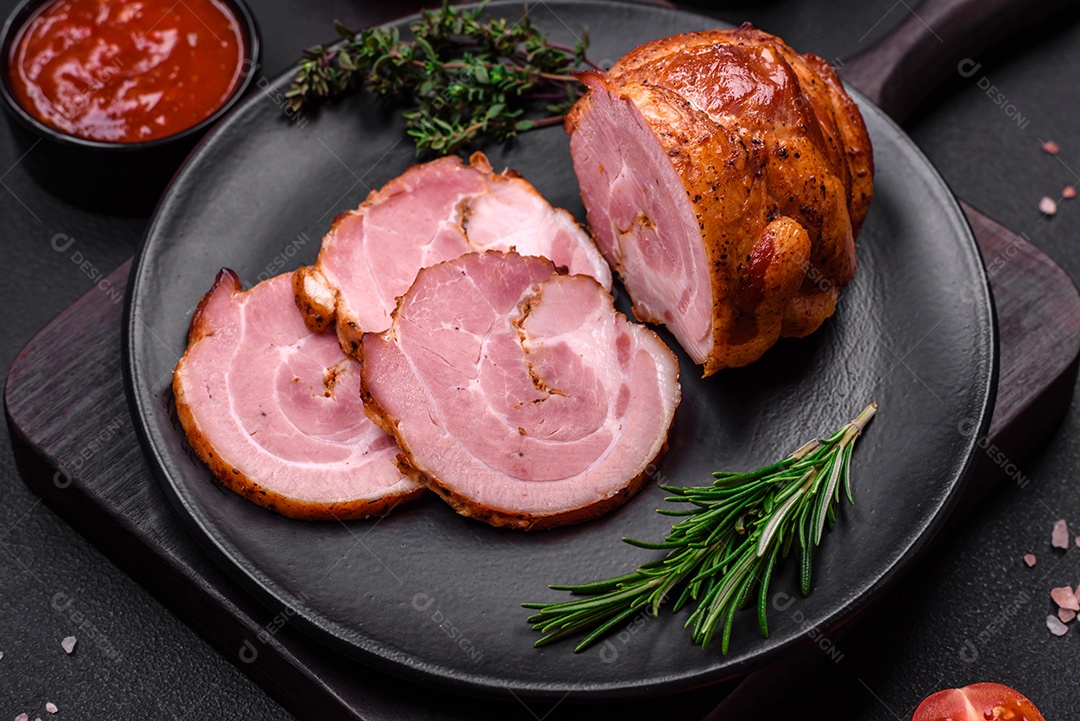 Delicioso rolo de carne fresca assada com especiarias e ervas em um fundo escuro de concreto