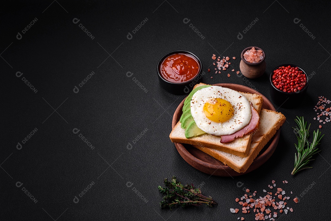 Delicioso café da manhã inglês nutritivo com ovos fritos, tomates, bacon e feijão em um fundo escuro de concreto