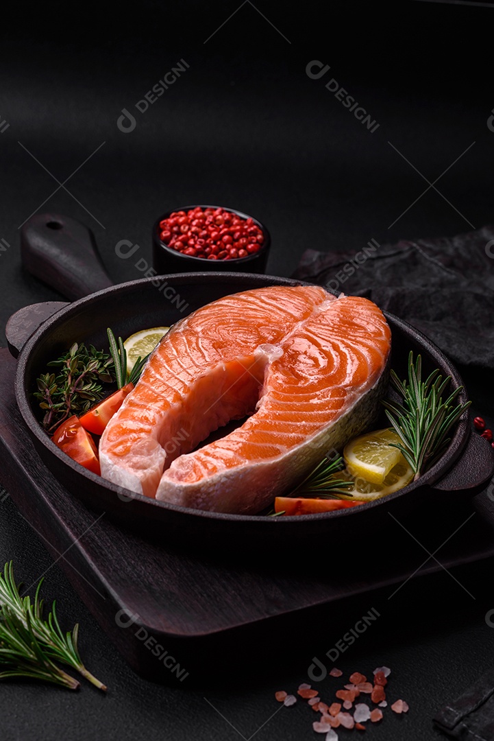 Bife de peixe vermelho cru fresco com especiarias e ervas sobre um fundo escuro de concreto