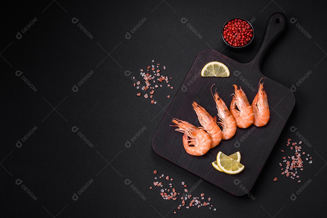 Camarão tigre ou lagostim fervido com especiarias e sal sobre um fundo escuro de concreto